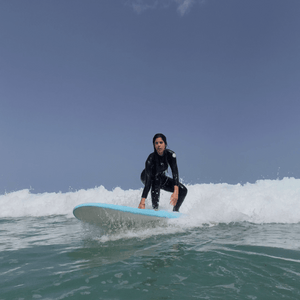 Surfer learning to ride waves during 1-day surf course at Famara Beach in Lanzarote