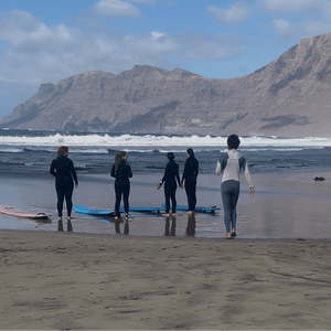 Small group surf lesson on Famara Beach Lanzarote with instructors and surfers preparing by the shore