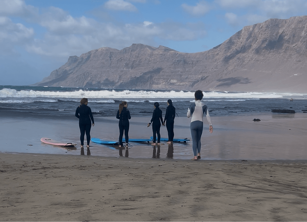 Small group surf lesson on Famara Beach Lanzarote with instructors and surfers preparing by the shore